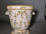 a white vase with a green and yellow design on it