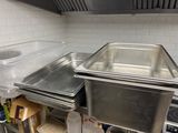 several pans are lined up on a shelf in a kitchen