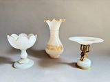trois vases et un bougeoir posés sur une table
