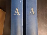 two blue books sitting on top of a table next to each other