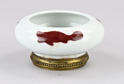 un petit bol blanc orné d'un poisson rouge