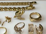 a lot of gold jewelry on a white surface