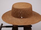 un chapeau de paille posé sur un support en bois