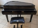 a piano and stool in a room with a painting on the wall