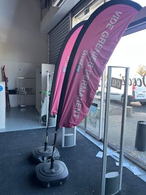 un drapeau rose hissé sur un mât devant un magasin