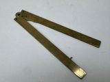 a pair of brass rulers sitting on top of a white table