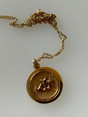 un gros plan sur un collier en or orné d'une abeille