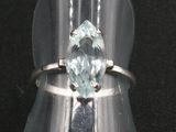 un gros plan d'une bague en argent sertie d'une topaze bleue