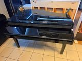 a black piano sitting on a tiled floor in a kitchen