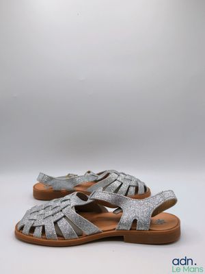 une paire de sandales argentées sur fond blanc