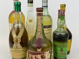 bottles of different types of alcohol lined up on a white surface