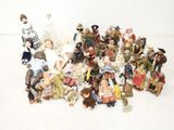 a lot of dolls and figurines sitting on the floor
