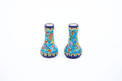 deux petits vases posés l'un à côté de l'autre sur une surface blanche