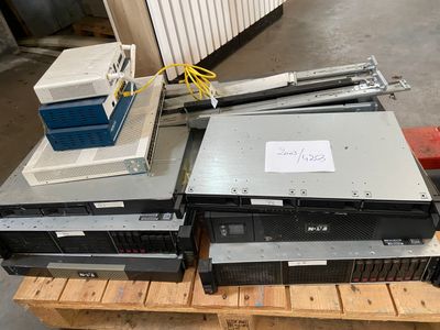 a pile of computer equipment sitting on a pallet in a warehouse