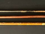 four baseball bats are lined up on a black surface