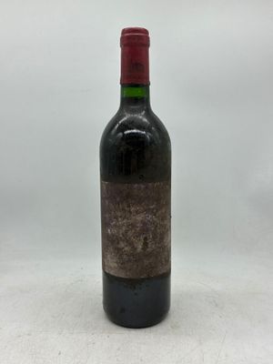 une bouteille de vin rouge posée sur une table blanche