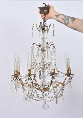 a person holding a chandelier that is hanging from the ceiling