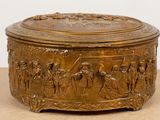 a gold box with a scene on it sitting on a table