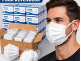 un homme portant un masque, à côté d'une boîte de masques jetables