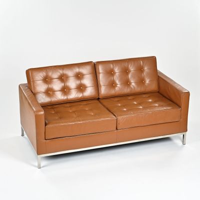 a brown leather couch sitting on a white surface
