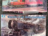 two model trains sitting on a table next to each other