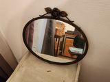 a mirror sitting on top of a dresser next to a window