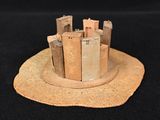 a small model of a castle on a black surface