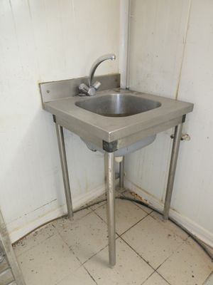 une photo d'une salle de bains avec un lavabo et une échelle