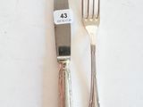 deux fourchettes et un couteau sur une table blanche