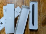 a black pen sitting in a white box on a wooden table