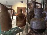 many vases that are on display in a glass case