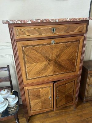 une armoire en bois avec un plateau en marbre, placée dans un coin de la pièce