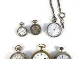 many different types of pocket watches displayed on a white surface