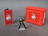 toy figurine of a man in a black suit with a microphone and a red box