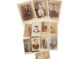 Plusieurs vieilles photographies d'hommes et de femmes sont exposées sur une surface blanche