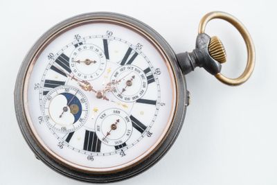 gros plan d'une montre de poche sur une surface blanche