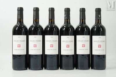 six bottles of wine are lined up in a row on a white surface