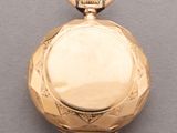 an image of a gold pocket watch on a gray surface