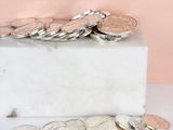 a pile of coins sitting on top of a marble block