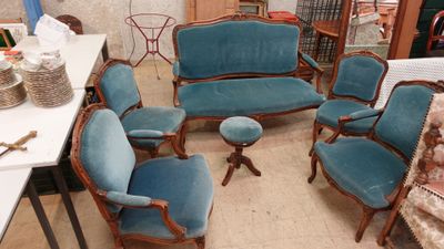 plusieurs chaises et une table dans une pièce avec beaucoup de meubles