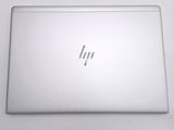 the back of a laptop computer sitting on top of a white table