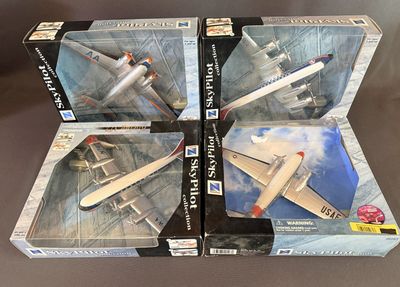 trois boîtes contenant des maquettes d'avions, posées sur une table