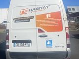 a white van parked in a parking lot with a blue sky in the background