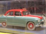 a green and red toy car in a clear display case