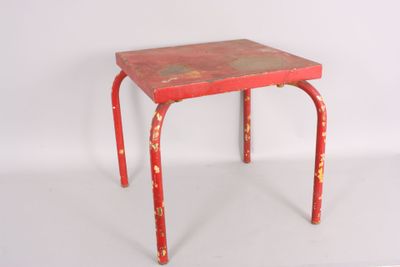 an old red metal stool with a red top on a white surface