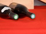 two bottles of wine sitting on a red table