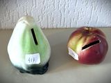 deux figurines représentant des pommes et une poire posées sur une table