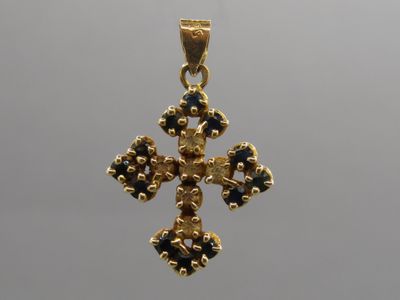une image représentant une croix en or ornée de pierres bleues