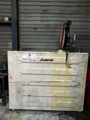 un réfrigérateur blanc posé dans un garage, avec un vélo posé dessus