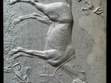 a stone plaque with a horse and a bird on it